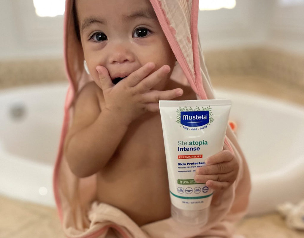Baby holding Mustela skincare
